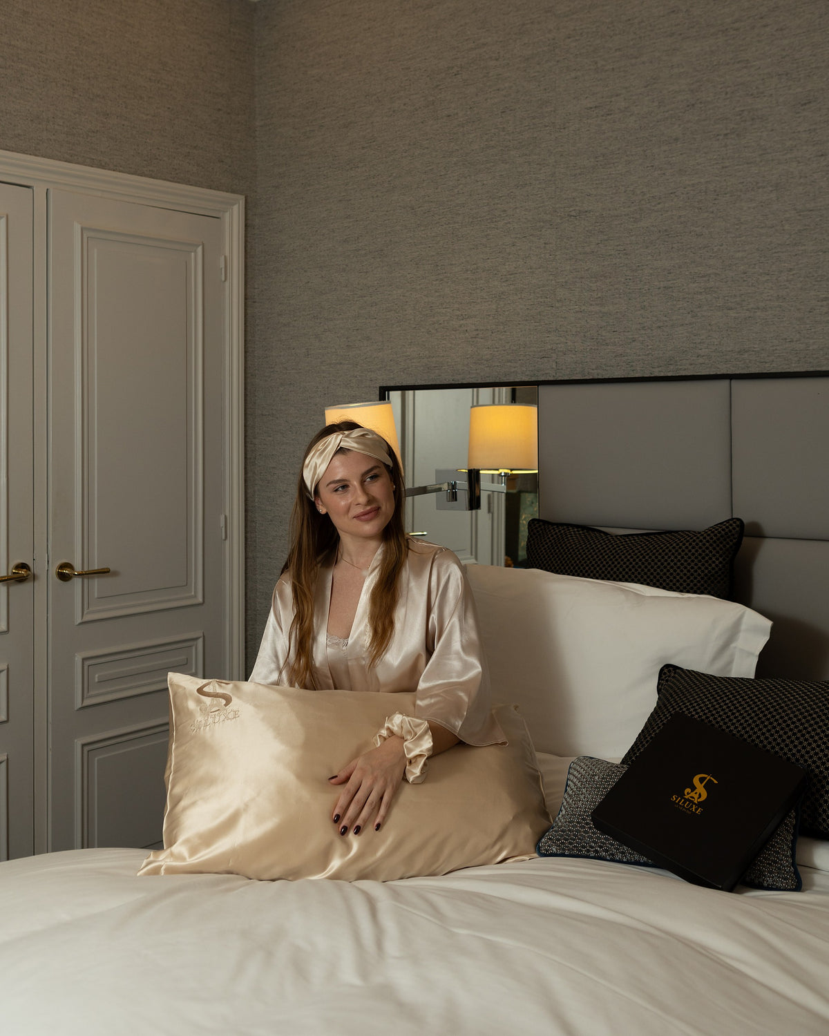 Siluxe silk pillowcase in Gold in a Haussmann bedroom, a Siluxe gift box on the bed